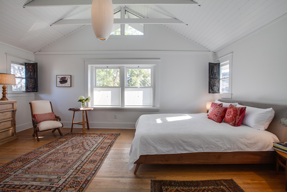 Imagen de dormitorio marinero con paredes blancas, suelo de madera en tonos medios y suelo marrón