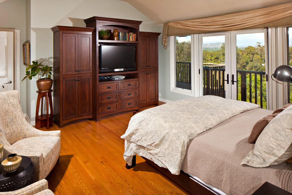 Modelo de dormitorio principal de estilo americano de tamaño medio con paredes grises y suelo de madera en tonos medios