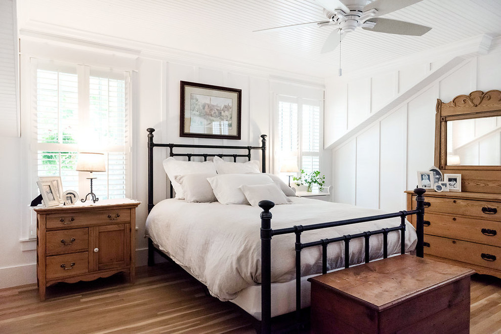 Idee per una camera matrimoniale stile americano con pareti bianche, pavimento in legno massello medio e pavimento marrone
