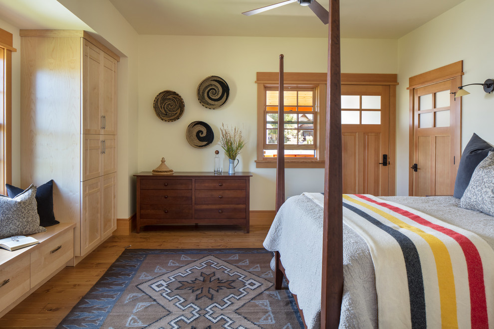 Ejemplo de dormitorio principal de estilo americano sin chimenea con paredes blancas y suelo de madera en tonos medios