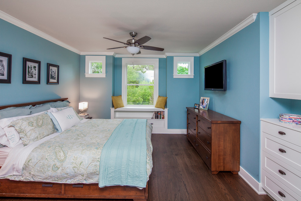 Idée de décoration pour une chambre parentale tradition de taille moyenne avec un mur bleu et un sol en bois brun.
