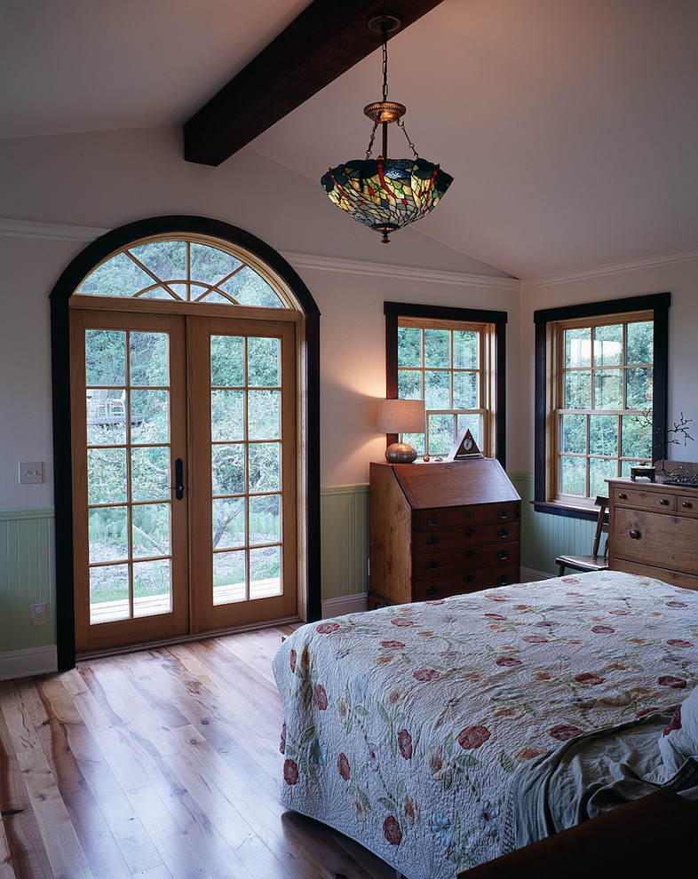 Diseño de dormitorio principal de estilo americano de tamaño medio con suelo de madera clara