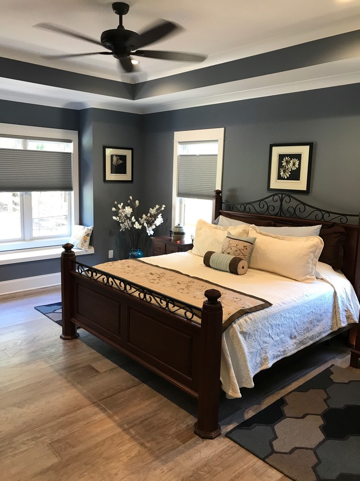 Mittelgroßes Uriges Hauptschlafzimmer ohne Kamin mit grauer Wandfarbe, braunem Holzboden und braunem Boden in Raleigh