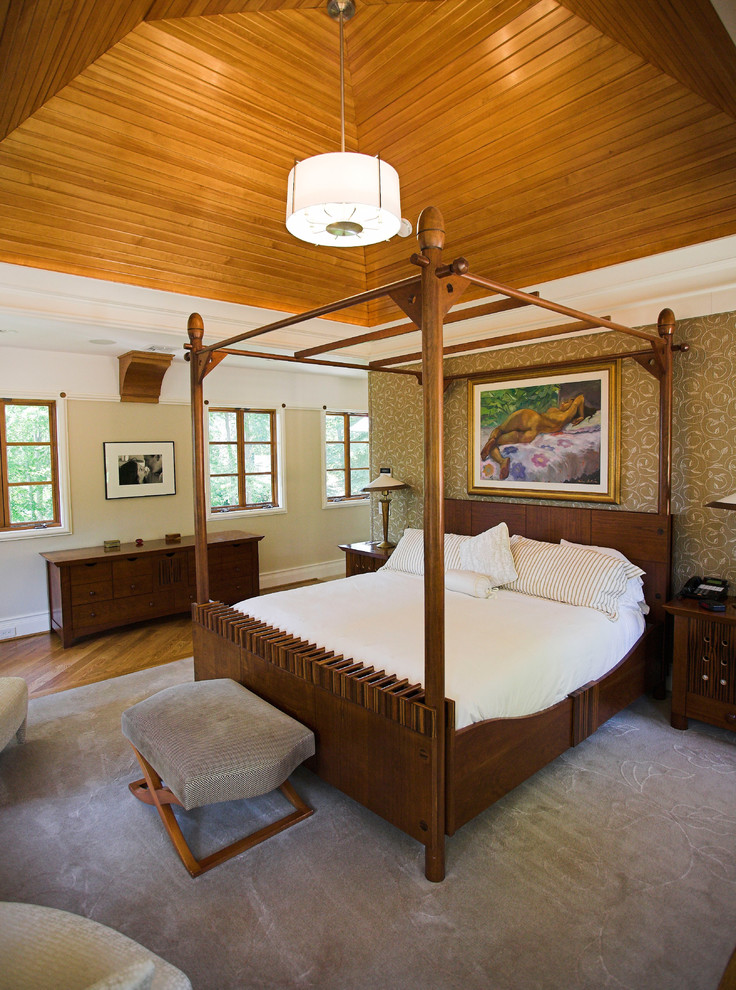 Modelo de dormitorio de estilo americano sin chimenea con paredes beige y suelo de madera en tonos medios