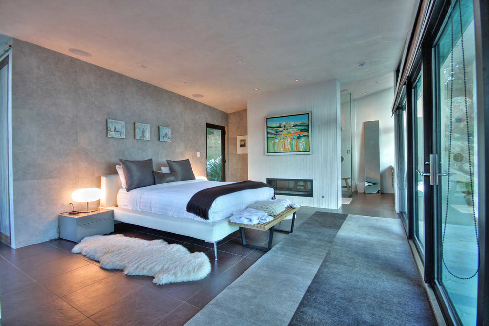 Cette image montre une chambre minimaliste avec un mur gris et une cheminée ribbon.