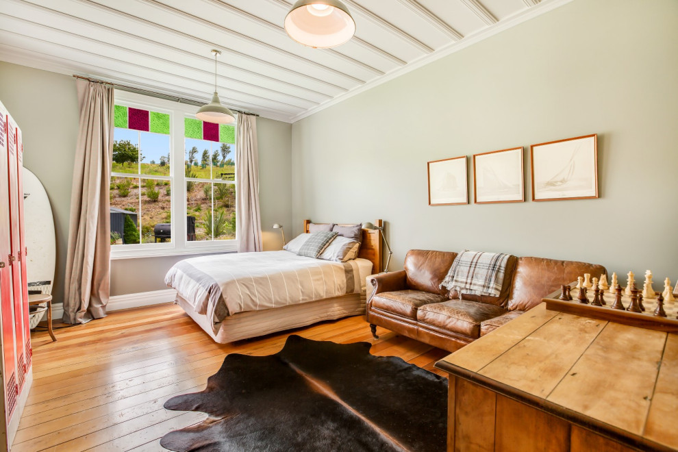 Esempio di una camera da letto country con pareti grigie, pavimento in legno massello medio e pavimento marrone