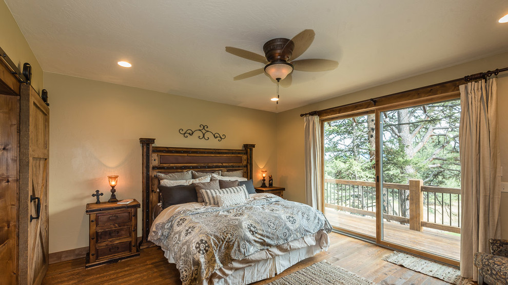 Imagen de dormitorio principal rural grande con paredes beige, suelo de madera en tonos medios y suelo beige