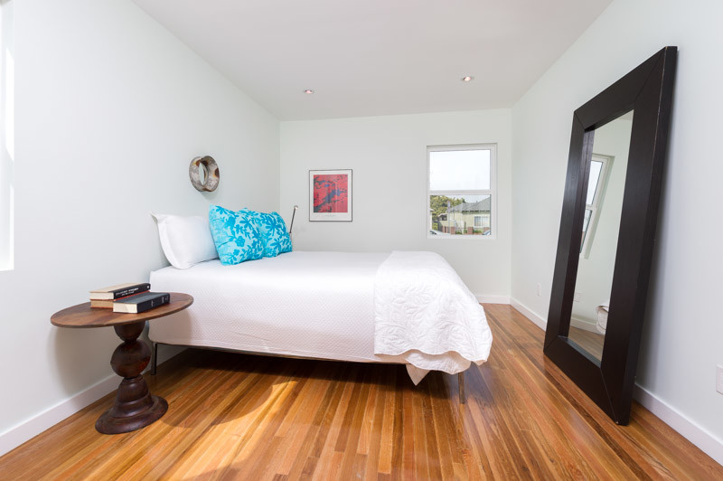 Inspiration for a mid-sized timeless guest medium tone wood floor bedroom remodel in Los Angeles with white walls