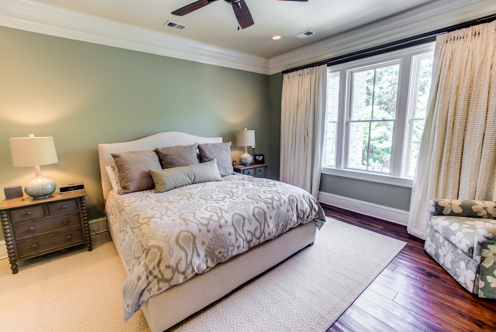 Aménagement d'une chambre d'amis classique de taille moyenne avec un mur vert, un sol en bois brun et aucune cheminée.