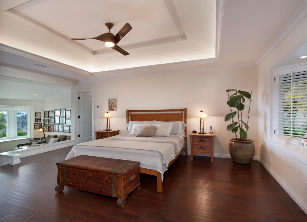 Modelo de dormitorio principal tradicional grande con paredes blancas, suelo de madera oscura, todas las chimeneas y suelo marrón