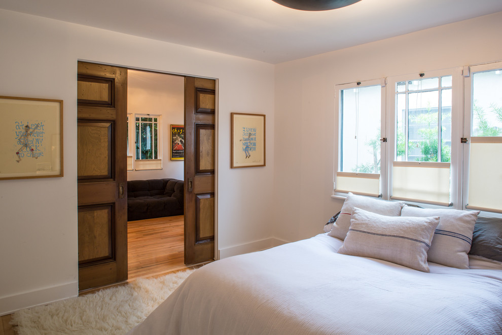 Esempio di una camera degli ospiti minimal di medie dimensioni con pareti bianche, parquet chiaro e nessun camino