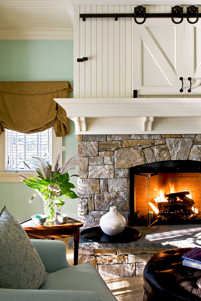 Exemple d'une chambre chic avec un mur vert, un manteau de cheminée en pierre et une cheminée standard.