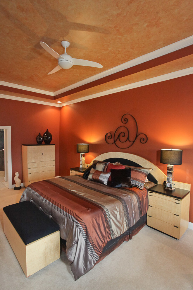 Immagine di una grande camera matrimoniale contemporanea con moquette e pareti arancioni