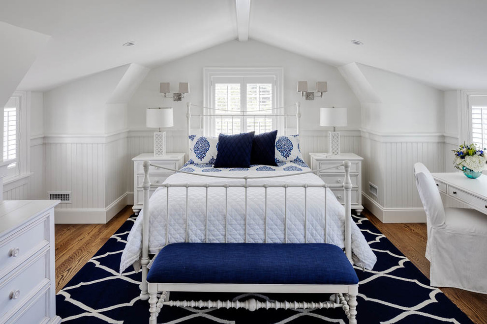 Diseño de dormitorio marinero sin chimenea con paredes blancas y suelo de madera en tonos medios