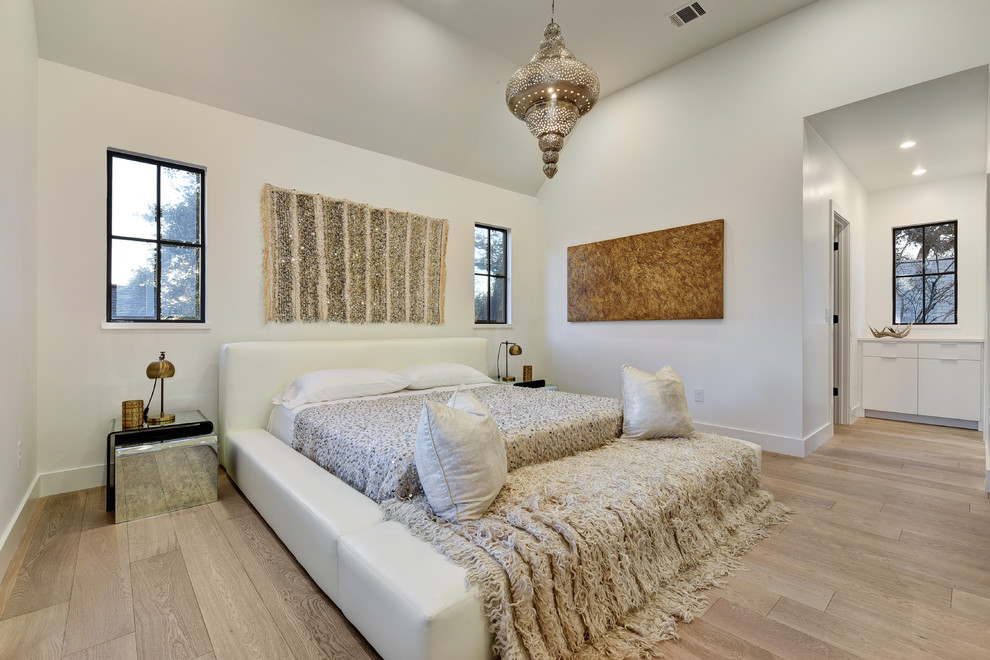 オースティンにあるコンテンポラリースタイルのおしゃれな主寝室 (白い壁、淡色無垢フローリング) のインテリア