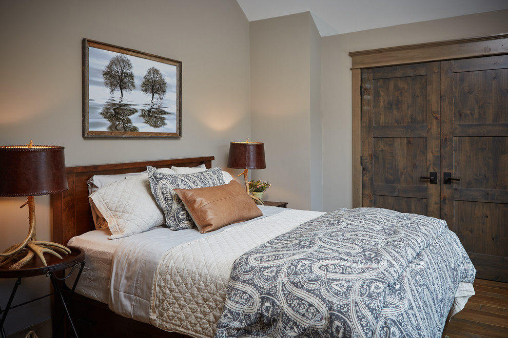 Diseño de habitación de invitados rural sin chimenea con paredes beige y suelo de madera en tonos medios