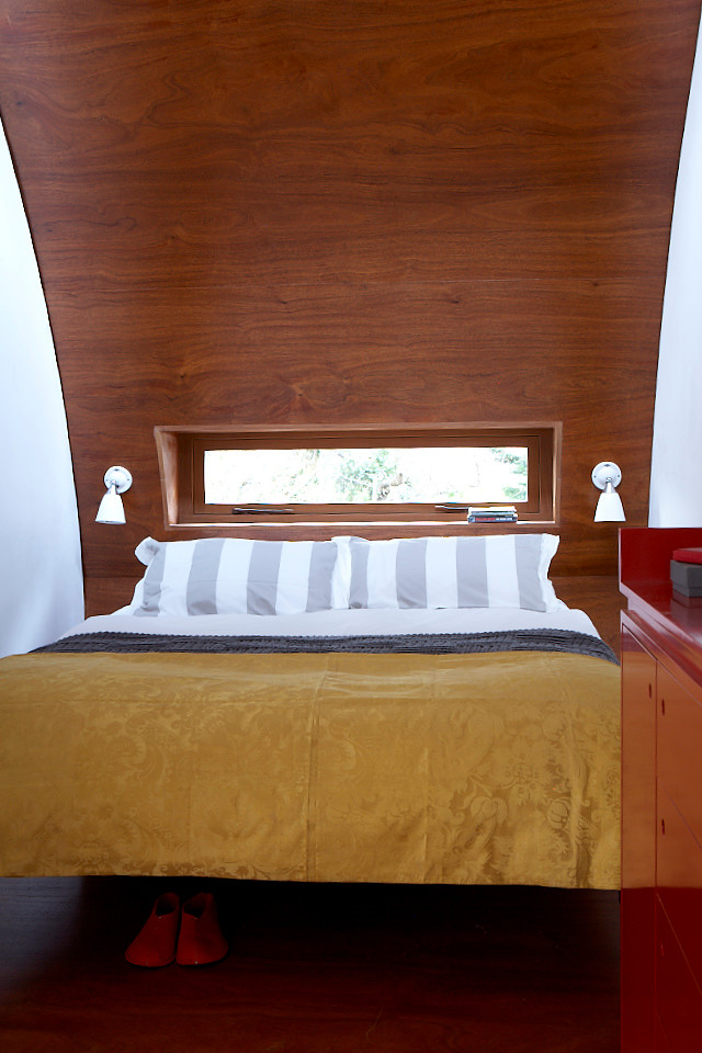 Imagen de dormitorio principal contemporáneo con suelo de contrachapado