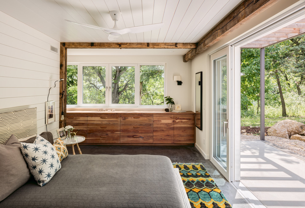 Kleines Modernes Hauptschlafzimmer mit Betonboden, beiger Wandfarbe und grauem Boden in Sonstige