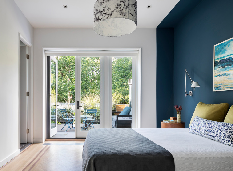 Idées déco pour une chambre parentale contemporaine avec un mur bleu et parquet clair.