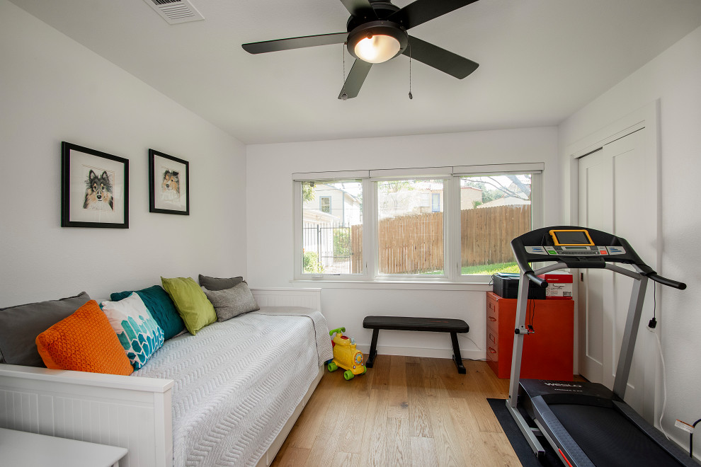 Immagine di una camera degli ospiti di medie dimensioni con pareti bianche, pavimento in legno massello medio e pavimento marrone