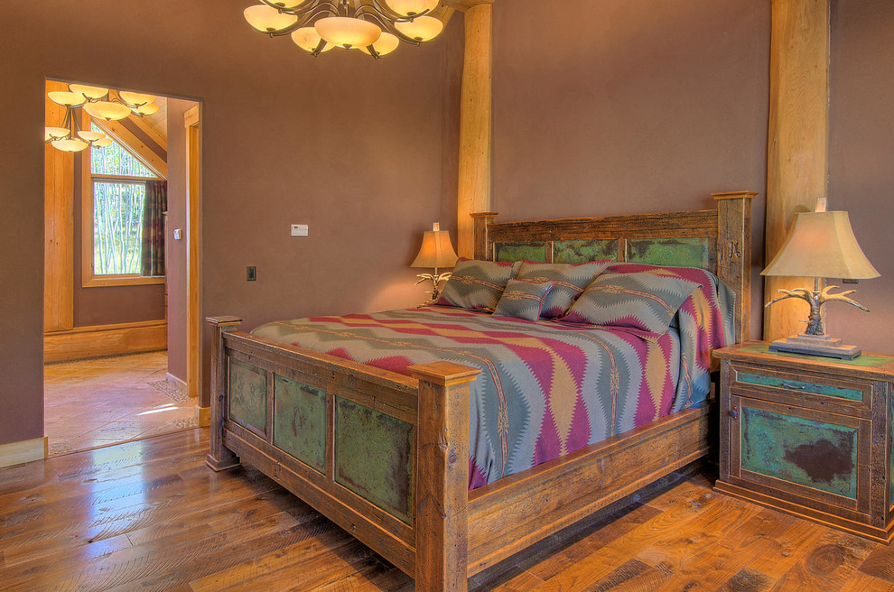Inspiration for a mid-sized rustic master medium tone wood floor and brown floor bedroom remodel in Denver with brown walls and no fireplace