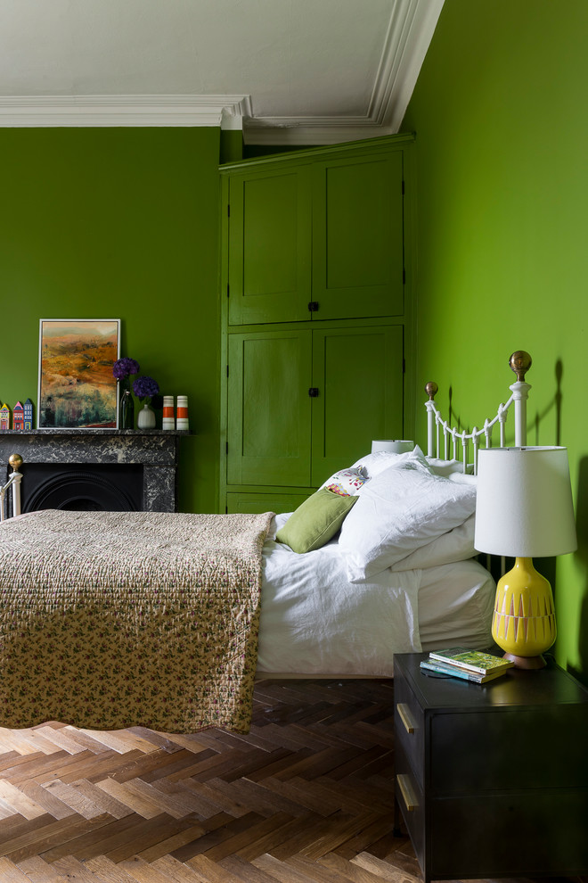 Inspiration pour une chambre d'amis nordique avec un mur vert et un manteau de cheminée en pierre.