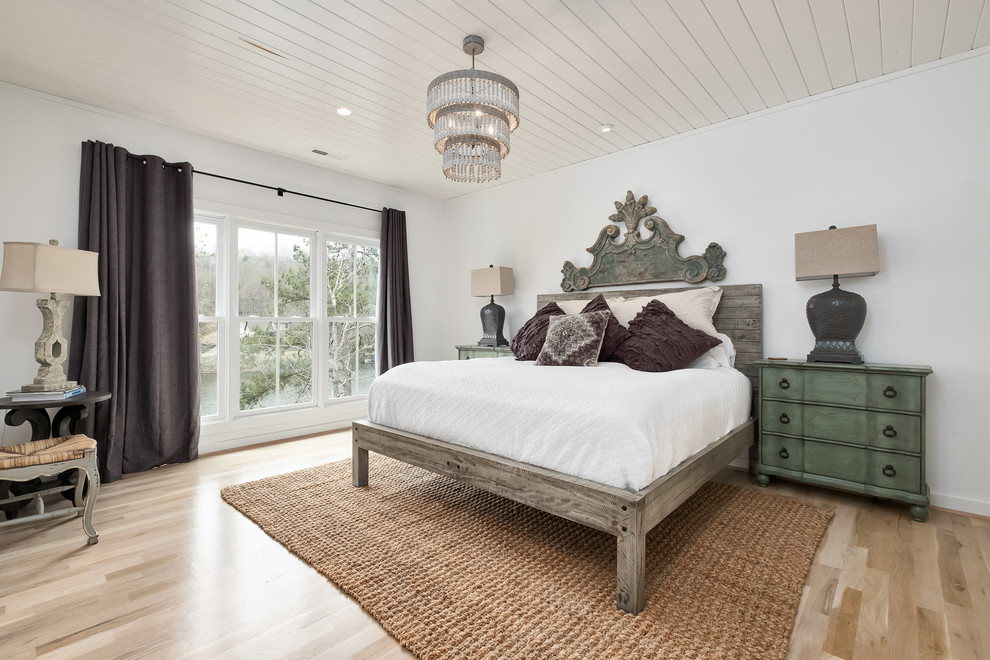 Modelo de dormitorio clásico renovado con paredes blancas, suelo de madera clara y suelo beige