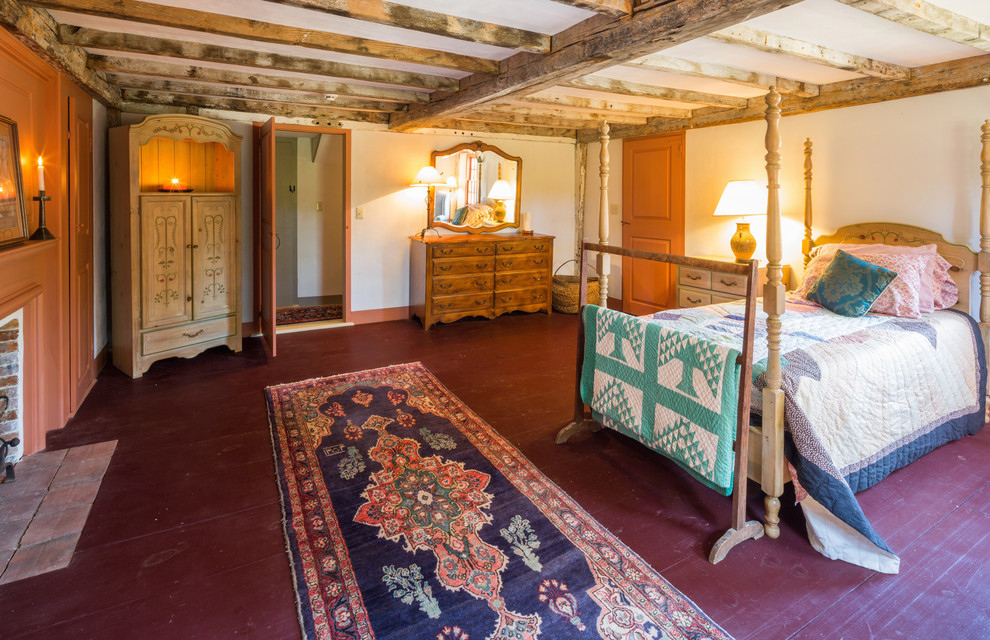 Foto på ett lantligt huvudsovrum, med vita väggar, målat trägolv, en standard öppen spis, en spiselkrans i trä och rött golv