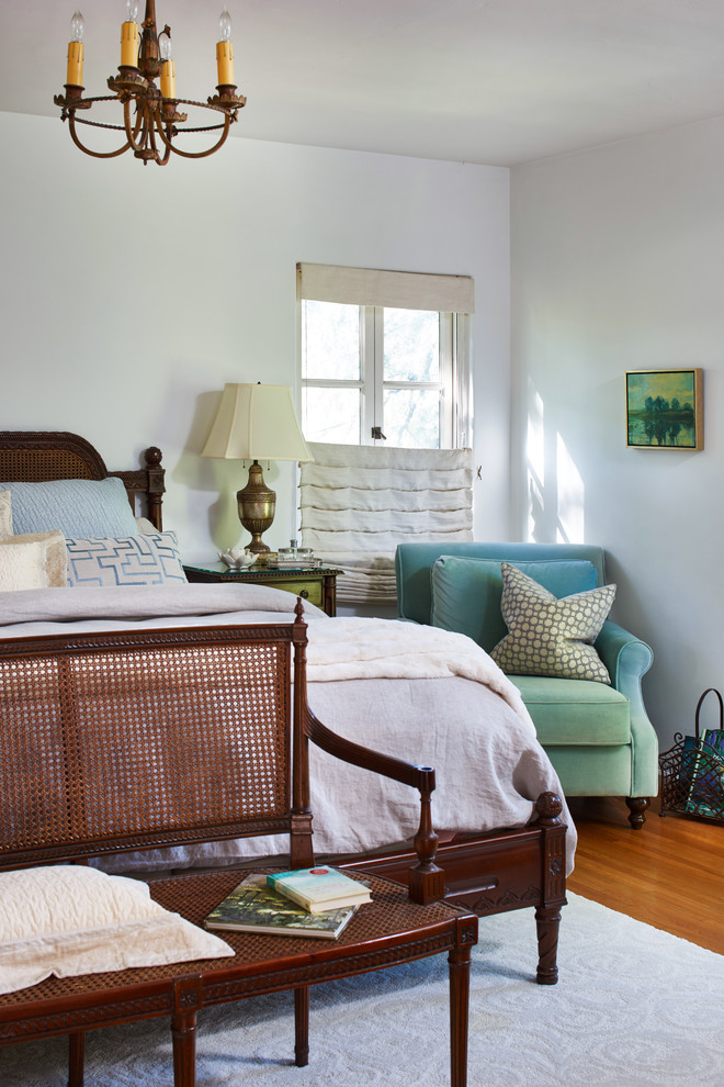 Aménagement d'une chambre parentale classique avec un mur blanc, un sol en bois brun et un sol orange.