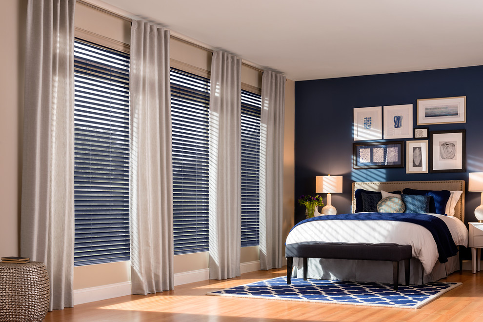 Imagen de habitación de invitados tradicional grande con paredes azules y suelo de madera en tonos medios