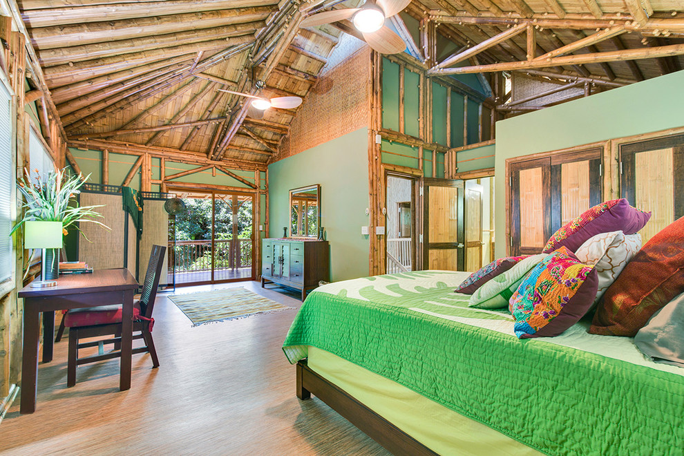 Esempio di una camera matrimoniale tropicale con pareti verdi e pavimento in bambù