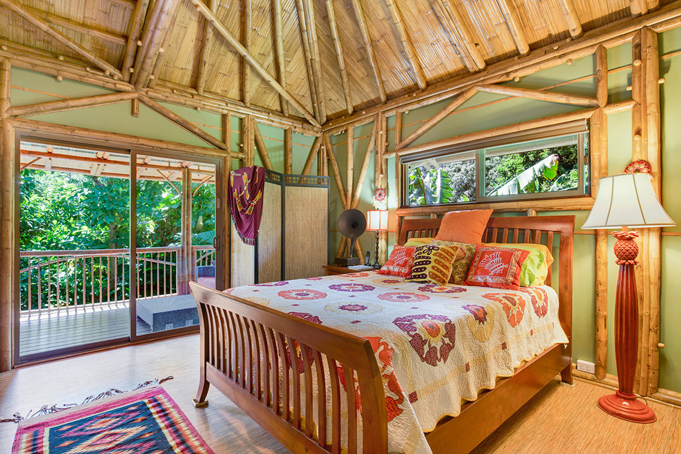 Esempio di una camera degli ospiti tropicale con pareti verdi e pavimento in bambù