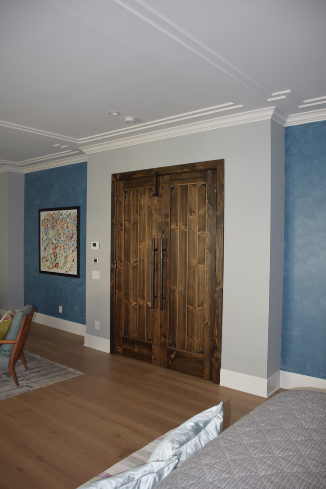 Exempel på ett stort klassiskt huvudsovrum, med blå väggar och mellanmörkt trägolv