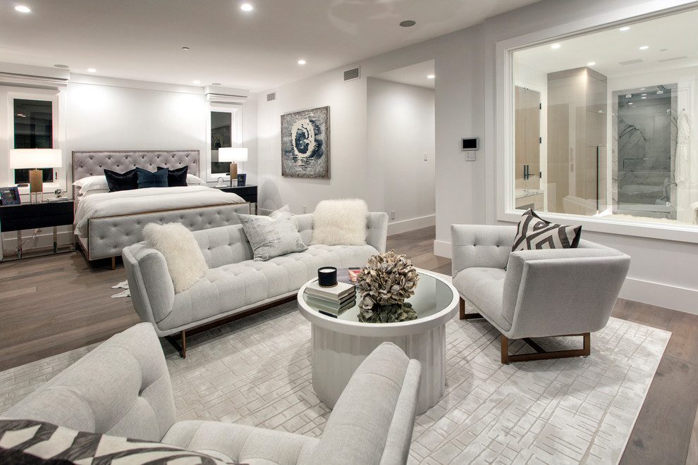 Expansive classic master bedroom in Orange County with grey walls, medium hardwood flooring, a ribbon fireplace, a concrete fireplace surround and brown floors.