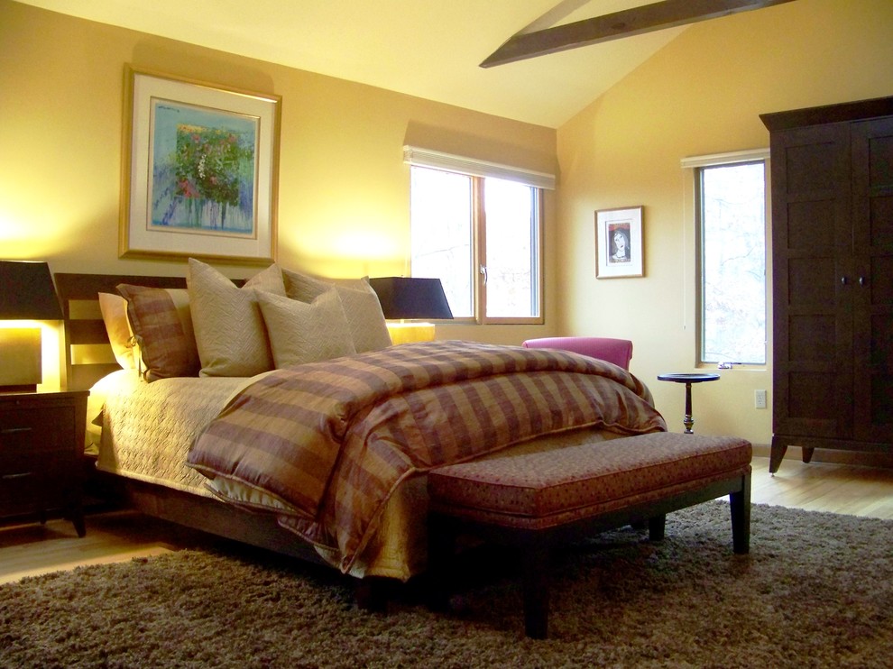 Exempel på ett stort klassiskt sovrum, med gula väggar, ljust trägolv och beiget golv