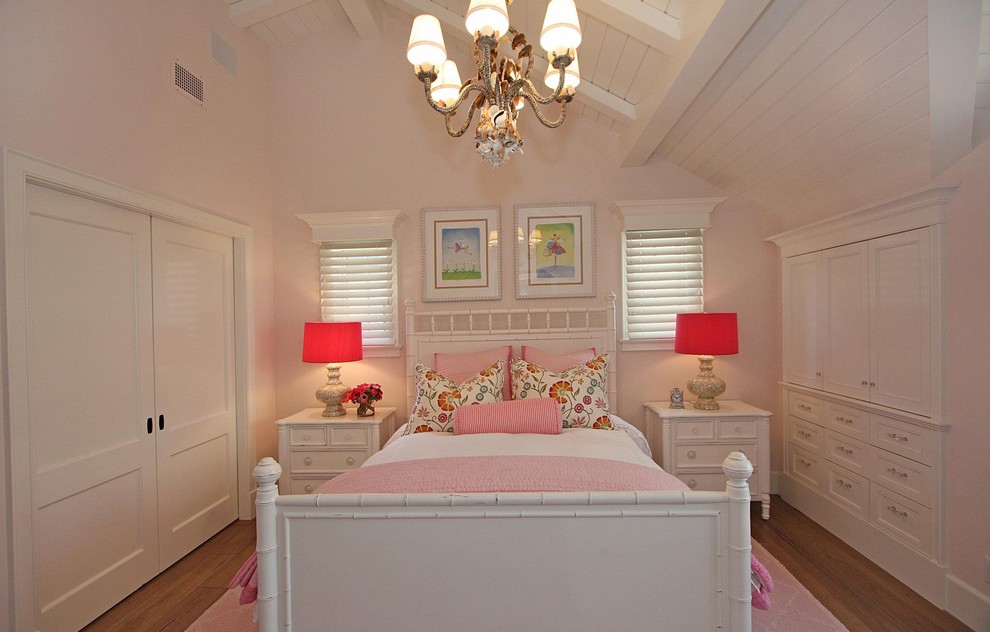 Example of a classic medium tone wood floor bedroom design with pink walls