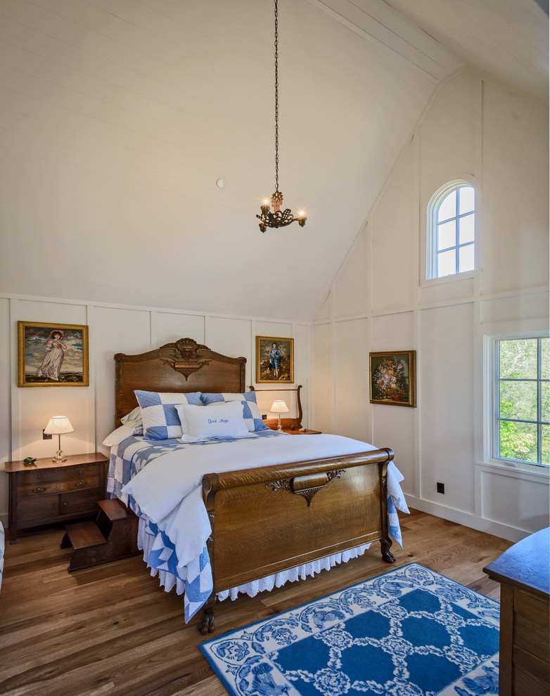 Imagen de habitación de invitados campestre con paredes blancas y suelo de madera en tonos medios