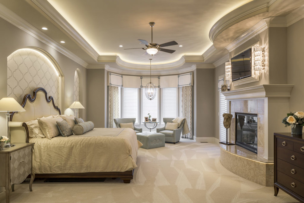 Diseño de dormitorio principal tradicional renovado grande con paredes grises, moqueta, todas las chimeneas, marco de chimenea de baldosas y/o azulejos y suelo beige