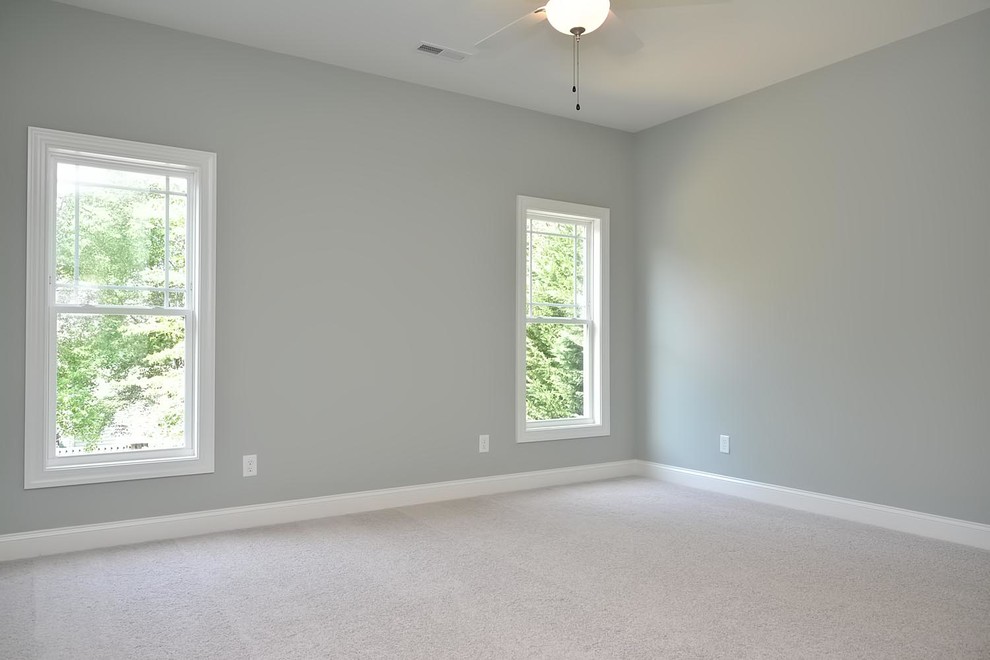 Ejemplo de dormitorio de estilo americano grande con paredes verdes y moqueta