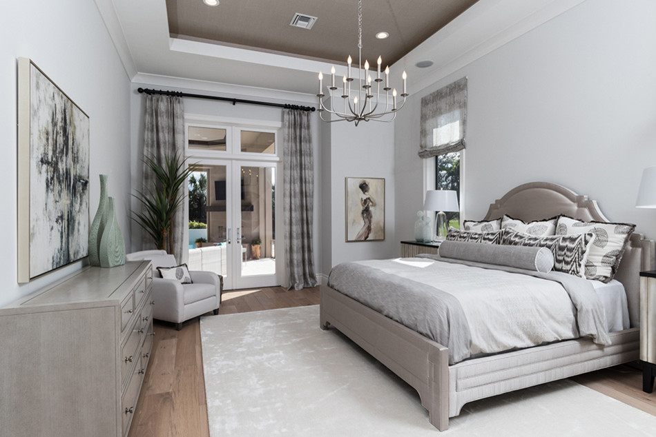 Ejemplo de dormitorio principal mediterráneo de tamaño medio con paredes grises, suelo de madera clara y suelo beige