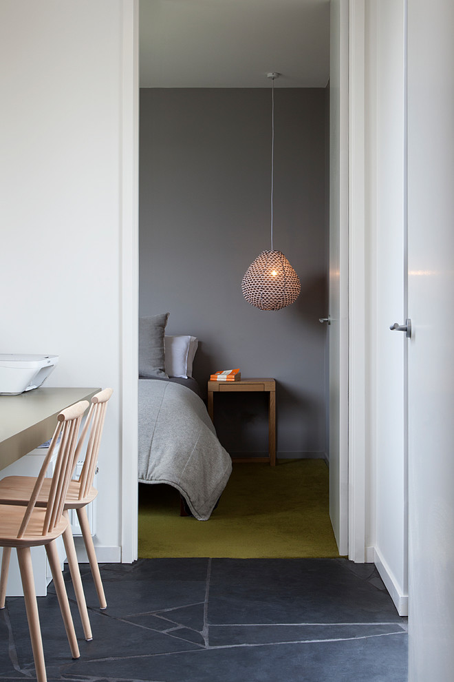 Aménagement d'une chambre avec moquette rétro avec un mur gris et un sol vert.