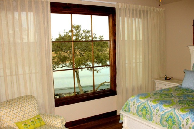 Idee per un'ampia camera degli ospiti tropicale con pareti beige e parquet scuro