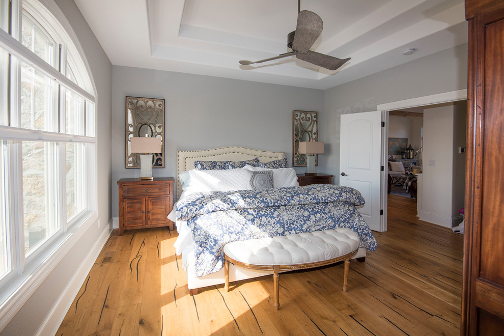 ミルウォーキーにある中くらいなエクレクティックスタイルのおしゃれな主寝室 (グレーの壁、無垢フローリング、茶色い床) のレイアウト