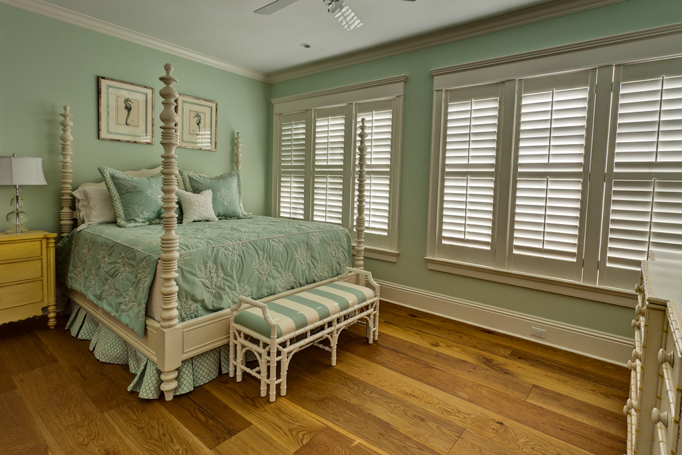 Immagine di una camera matrimoniale american style di medie dimensioni con pavimento in legno massello medio, nessun camino, pavimento marrone e pareti blu