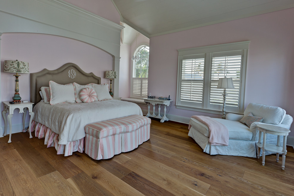 Idee per una camera matrimoniale american style di medie dimensioni con pavimento in legno massello medio, pareti rosa, nessun camino e pavimento marrone