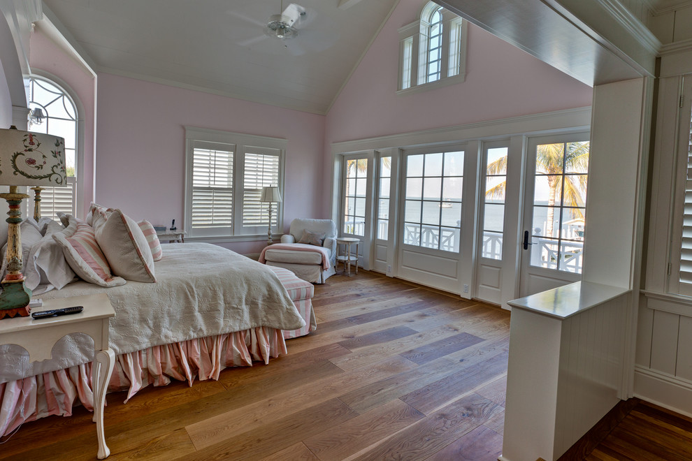 Пример оригинального дизайна: хозяйская спальня среднего размера в стиле кантри с паркетным полом среднего тона, розовыми стенами и коричневым полом без камина