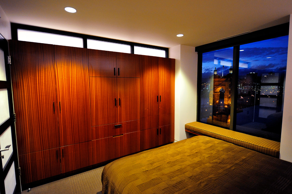 Cette image montre une chambre design de taille moyenne avec un mur blanc, aucune cheminée et un sol marron.