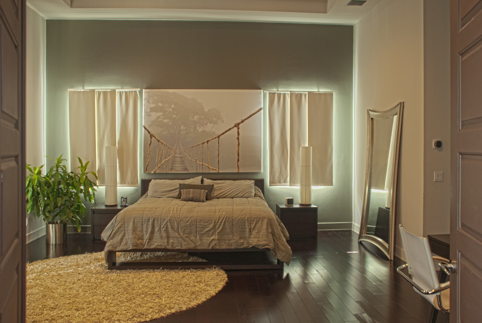 Imagen de dormitorio principal actual grande sin chimenea con paredes multicolor y suelo de madera oscura