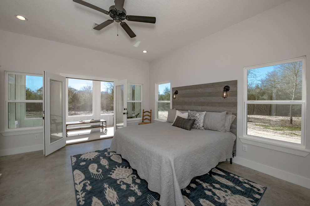 Foto de dormitorio principal campestre de tamaño medio con paredes blancas, suelo de cemento y suelo gris