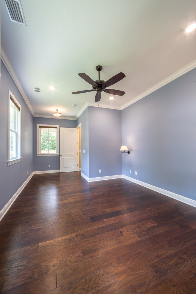 Aménagement d'une chambre parentale classique de taille moyenne avec un mur bleu, parquet foncé et un sol marron.